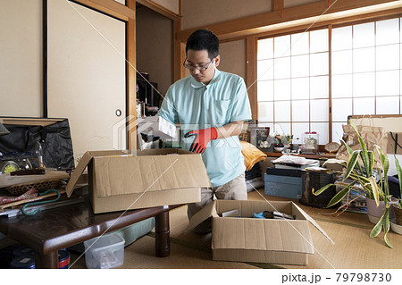 散らかった部屋の整理をする男性作業員 79798730