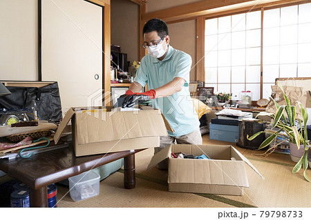 散らかった部屋の整理をする男性作業員 散らかった部屋の整理をする男性作業員 79798733