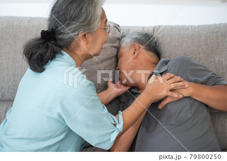 Asian old elderly man is In pain with his hands on his chest and having a heart attack in the Living room and his wife is shocked and confused, helpless. Concept of healthcare and Elderly caregivers Asian old elderly man is In pain with his hands on his chest and having a heart attack in the Living room and his wife is shocked and confused, helpless. Concept of healthcare and Elderly caregivers 79800250