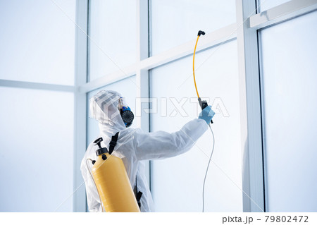 employee of a cleaning company disinfects the premises . 79802472
