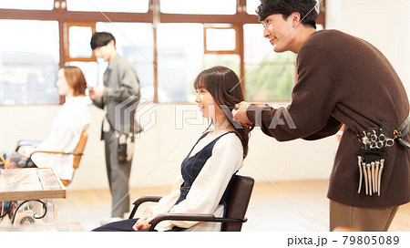 美容室にてヘアスタイリストと会話する女性客 79805089
