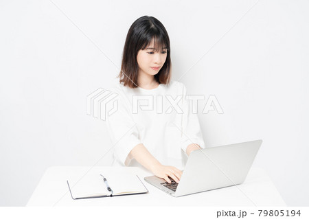 白背景の前でノートパソコンを使う若い女性 79805194