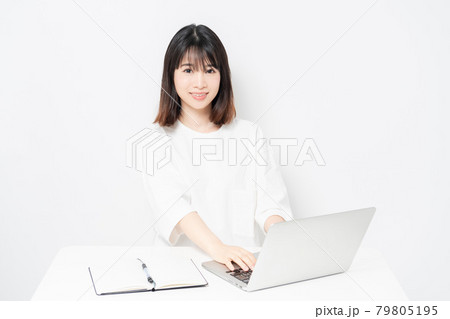 白背景の前でノートパソコンを使う若い女性 79805195