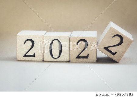 The year 2022 written on wooden cubes, finger flipping year to year, New year concept background, starting new natural modern colored design stylish 79807292