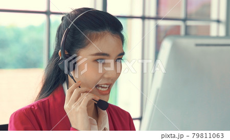 Businesswoman wearing headset working actively in office Businesswoman wearing headset working actively in office 79811063