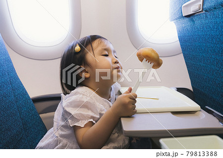 Baby eats on airplane 79813388