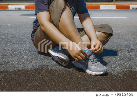 People sit and tie their shoelaces to exercise. 79815459