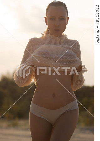 Sexy woman taking off top on beach - Stock Photo [79816064] - PIXTA