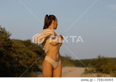 Sexy woman taking off top on beach - Stock Photo [79816064] - PIXTA