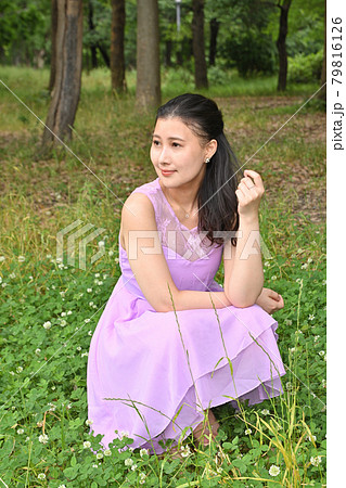 草原にしゃがむ女性 79816126