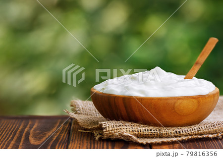 sour cream in wooden bowl on table outdoors sour cream in wooden bowl on table outdoors 79816356