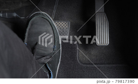 Man foot and accelerator and brake pedal inside the car or vehicle and copy space which black color leather shoe stepped on it for speed up or control automobile pace power. Automobile Driving concept 79817390