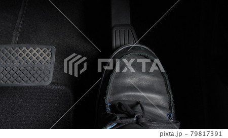 Man foot and accelerator and brake pedal inside the car or vehicle and copy space which black color leather shoe stepped on it for speed up or control automobile pace power. Automobile Driving concept 79817391