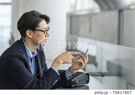 スマートホンを操作する30代のビジネスマン 79817867