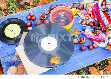 Yellow ceramic cup of herbal tea and vintage vinyl records on aged wooden background Yellow ceramic cup of herbal tea and vintage vinyl records on aged wooden background 79821487