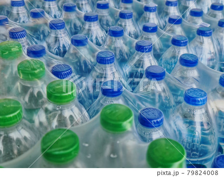High Angle View of Packs of Bottled Drinking Water with Blue and Green Caps 79824008