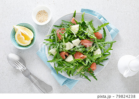 Salted salmon and arugula salad with fresh pineapple, top view 79824238