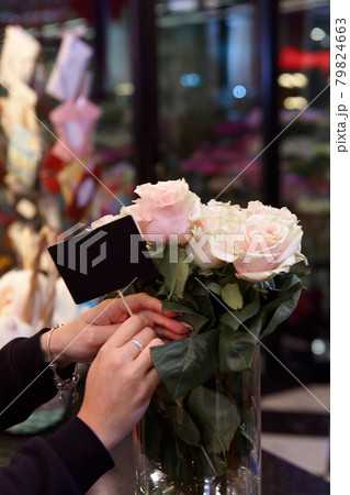 Flower seller is holding an empty sign for the price of roses. Flower seller is holding an empty sign for the price of roses. 79824663