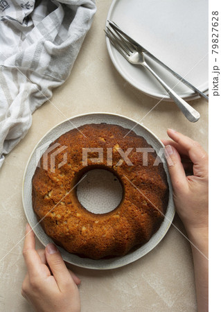 Chocolate bundt homemade cake with female hands holding freshly baked cake. Top view. 79827628