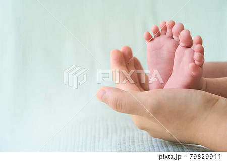 生まれたての赤ちゃんの足と母親の手 79829944