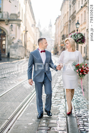 Middle aged couple in love, walking in elegant clothes outdoors in beautiful ancient European city 79830628