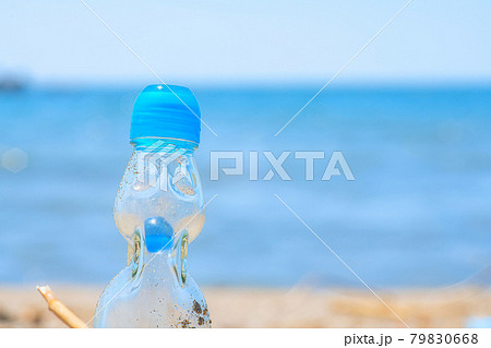 海と砂浜とラムネ瓶の写真素材