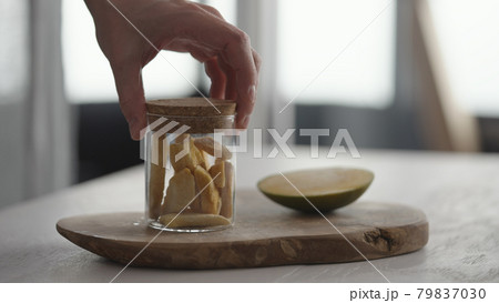 Man put sublimated mango next to fresh mango on olive board on white oak table Man put sublimated mango next to fresh mango on olive board on white oak table 79837030