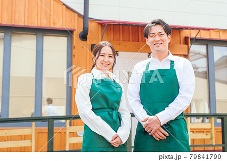 お店の前に立つエプロン姿の男女 79841790