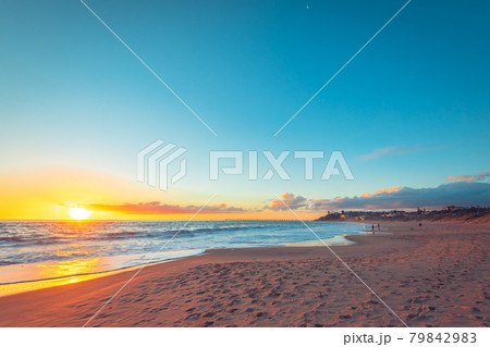 Dramatic sunset with people fishing from the beach 79842983