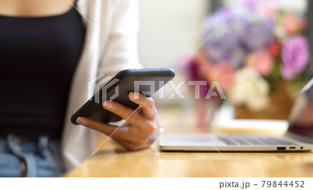 Cropped shot of female texting on smartphone 79844452