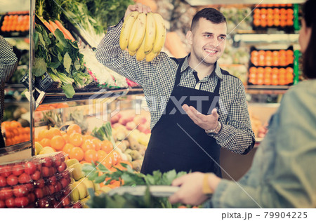 Male seller assisting in buying 79904225