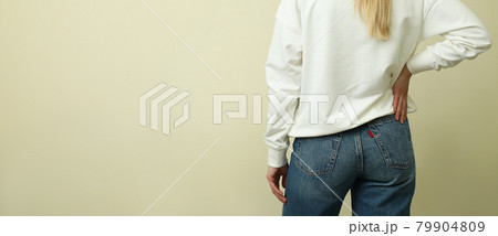Young woman in white sweatshirt against beige background 79904809