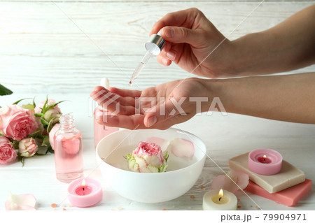 Female hands hold pipette with rose essential oil, close up Female hands hold pipette with rose essential oil, close up 79904971