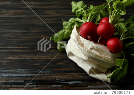Bag with radish on wooden background, space for text 79906178