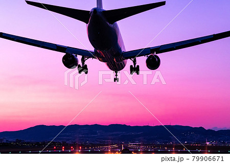 茜色の空の伊丹空港へ着陸する旅客機 79906671
