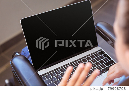 Disabled caucasian schoolgirl sitting in wheelchair using laptop, copy space on screen Disabled caucasian schoolgirl sitting in wheelchair using laptop, copy space on screen 79908708
