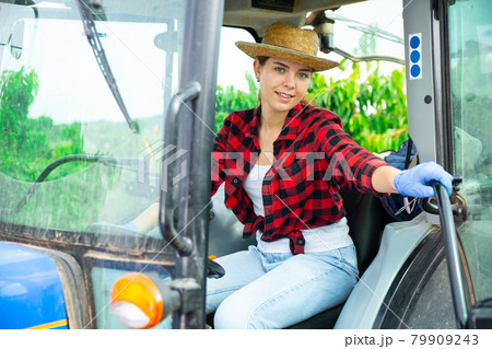 Girl farmer working on a tractor at a orchard 79909243