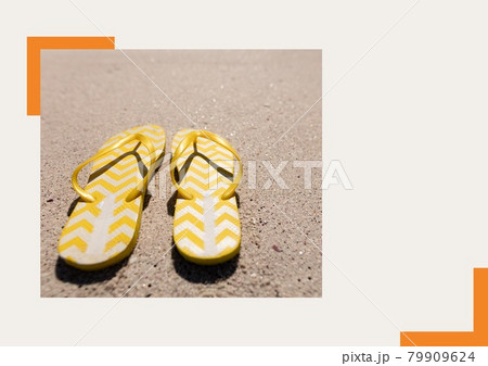 Photograph of yellow flip flops at the beach against grey background 79909624