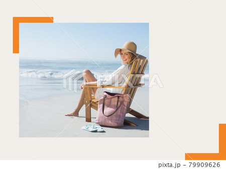 Photograph of caucasian woman sitting on a chair smiling at the beach against grey background Photograph of caucasian woman sitting on a chair smiling at the beach against grey background 79909626