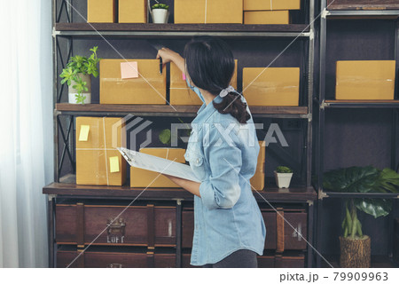Woman checking stock goods supply delivery package shipping use document checklist. Asian woman startup small business at home office. Online entrepreneur asian woman use tablet checking online order Woman checking stock goods supply delivery package shipping use document checklist. Asian woman startup small business at home office. Online entrepreneur asian woman use tablet checking online order 79909963