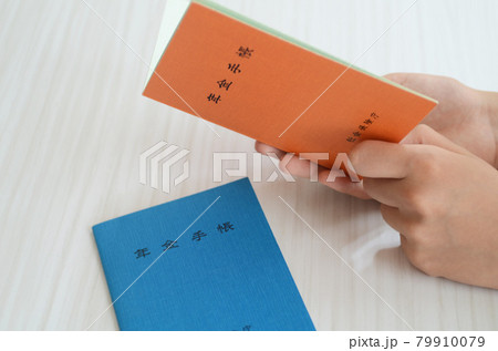 女性が年金手帳を開いて見ています。 79910079