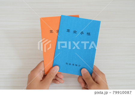 女性が年金手帳を二冊持っています。 女性が年金手帳を二冊持っています。 79910087