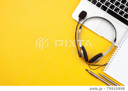 Office desk with headset and laptop. Work from home Office desk with headset and laptop. Work from home 79910998