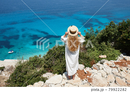 Woman in hat looking at beautiful blue lagoon Woman in hat looking at beautiful blue lagoon 79922282