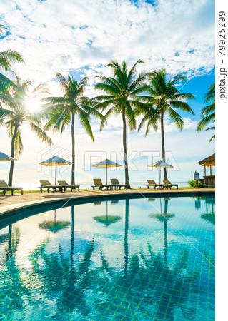 Beautiful luxury umbrella and chair around outdoor swimming pool in hotel and resort with coconut palm tree on blue sky Beautiful luxury umbrella and chair around outdoor swimming pool in hotel and resort with coconut palm tree on blue sky 79925299