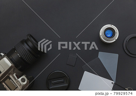 Photographer workplace with dslr camera system, camera cleaning kit, lens and camera accessory on dark black table background. Hobby travel photography concept Flat lay top view copy space 79929574