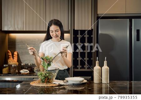 Asian housewife preparing fresh vegetables to make salad at home kitchen counter. 79935355