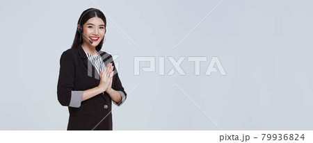 Smiling Asian businesswoman customer support phone operator with Thai culture Sawasdee,Welcome expression Sawasdee isolated over gray background. call center and customer service concept. 79936824