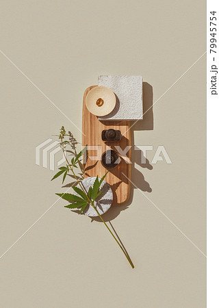 CBD oil in brown bottle with dropper, cannabis branch, capsules on wooden podium Flat lay 79945754