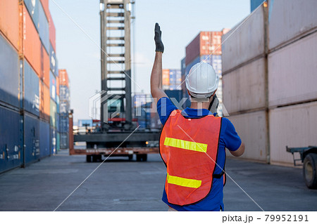 Back of foreman or cargo container worker give hand signal to crane movement in workplace are 79952191